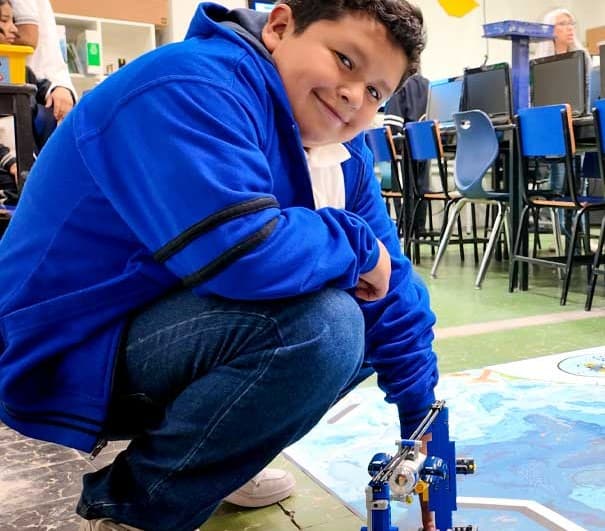 A student squatted down at Christel House Mexico