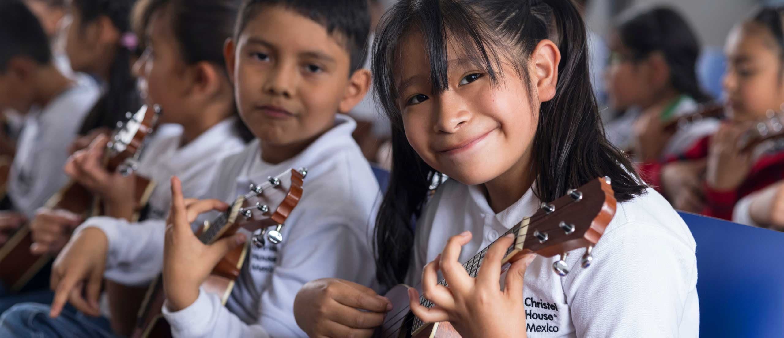 Students learning an instrument at Christel House Mexico