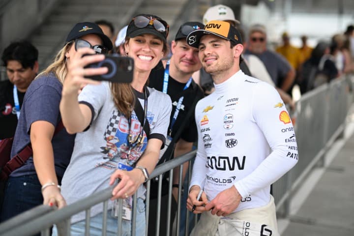 Pato O'Ward taking a photo with a fan