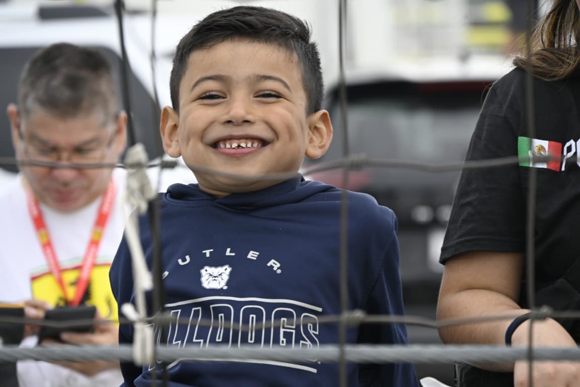 A child in the grandstands with a big smile